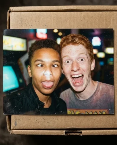 Nostalgic Flash — 80s Arcade Night 5 — Nano Banana AI Prompt: Two friends at an arcade cabinet — a young person with short dark hair and warm...