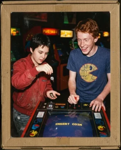 Nostalgic Flash — 80s Arcade Night 6 — Nano Banana AI Prompt: Two friends — a young person with short dark hair and warm brown skin, and a lan...