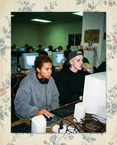 Nostalgic Flash — Late 90s Internet Café 1 — Nano Banana AI Prompt: Two friends at side-by-side CRT monitors in a dimly lit internet café — a young...