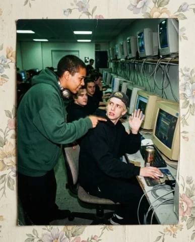 Nostalgic Flash — Late 90s Internet Café 5 — Nano Banana AI Prompt: Two friends at the front counter of a dimly lit internet café — a young person w...