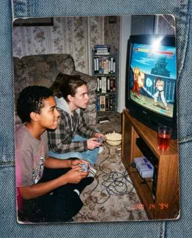 Gaming with [Character] — SNES Era, 1994 2 — Nano Banana AI Prompt: In the mid-90s living room — a young person with short dark hair and warm brown...