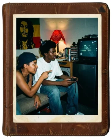 Gaming Buddies — PS2 Era, 2004 2 — Nano Banana AI Prompt: In a college dorm room — a tall lanky Black teenager with an afro pick tucked in...