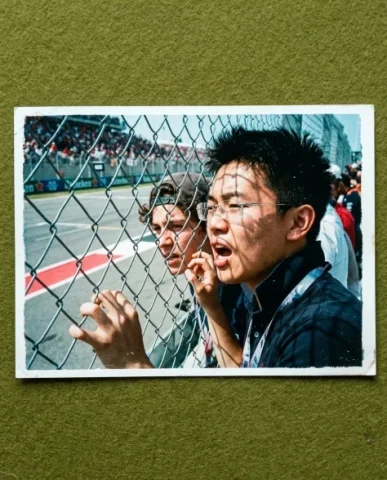 Pit Lane — F1 Race, 2008 2 — Nano Banana AI Prompt: Two friends in the F1 grandstand seats — a young person with short dark hair and...