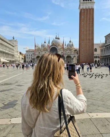 Wide-Angle Smartphone Selfie at Italian Landmark 6 — Nano Banana AI Prompt: Piazza San Marco looking out at the vast square. The camera captures her back —...