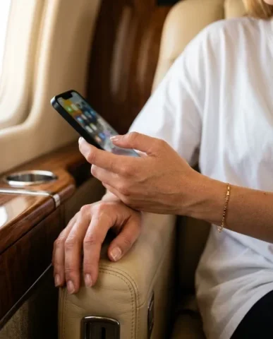 Luxury Private Jet Cabin Lifestyle Portrait 5 — Nano Banana AI Prompt: Warm golden cabin ambient light wraps around her from the left side, creating so...