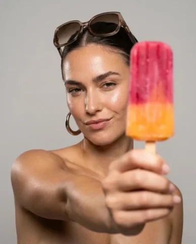 High-Fashion Beauty Close-Up Portrait with Treat 2 — Nano Banana AI Prompt: The popsicle's vivid raspberry-pink and tangerine-orange gradient provides chrom...