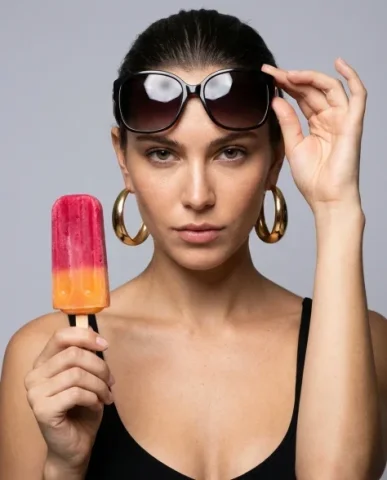 High-Fashion Beauty Close-Up Portrait with Treat 6 — Nano Banana AI Prompt: Fashion portrait of a woman pulling designer sunglasses down to peer over the fr...
