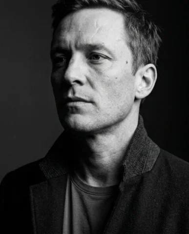 High-Contrast Black and White Cinematic Portrait 4 — Nano Banana AI Prompt: The subject walks away from the camera down a minimal clean corridor, seen from...