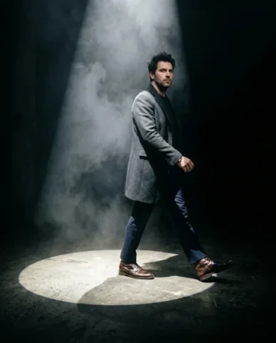 Dramatic Spotlight Portrait in Total Darkness 2 — Nano Banana AI Prompt: They are captured mid-step — one polished leather boot firmly inside the illumin...