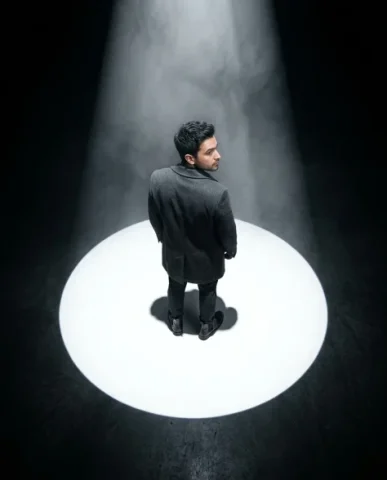 Dramatic Spotlight Portrait in Total Darkness 4 — Nano Banana AI Prompt: The charcoal overcoat's texture is visible from above — structured shoulders, th...