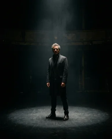 Dramatic Spotlight Portrait in Total Darkness 7 — Nano Banana AI Prompt: The once-sharp circle of light on the ground has softened at its edges, the boun...