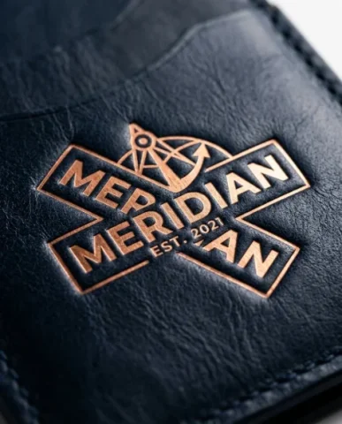 Premium Branded Merchandise Capsule Collection 4 — Nano Banana AI Prompt: Extreme macro close-up of a copper logo debossed into a deep midnight navy leath...