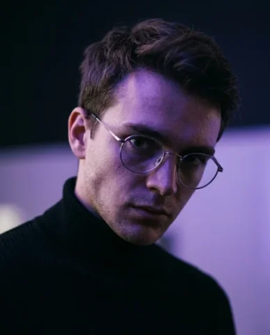 Minimalist Cinematic Neon Portrait 5 — Nano Banana AI Prompt: His face without the glasses reveals his eyes more clearly — contemplative and f...