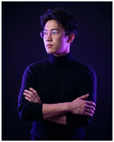 Minimalist Cinematic Neon Portrait 7 — Nano Banana AI Prompt: Man with chin lowered looking up through wire-frame glasses with brooding intens...