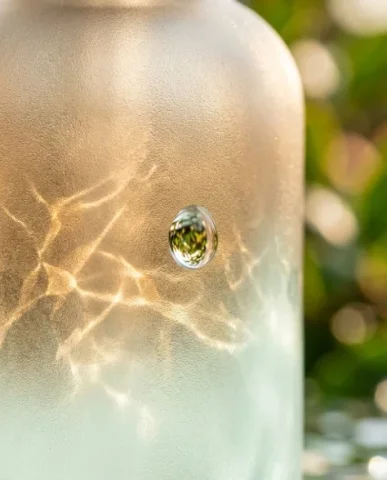 Eco-Friendly Skincare Bottle in Serene Natural Setting 4 — Nano Banana AI Prompt: Extreme macro close-up of the frosted glass surface of a minimalist skincare bot...