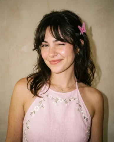 Soft Flash Coquette Portrait with Butterfly Clip 1 — Nano Banana AI Prompt: Her shoulders are slightly turned with head tilted and one eye closed in a playf...