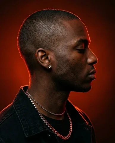 Red-Orange Dramatic Lighting Close-Up Portrait 4 — Nano Banana AI Prompt: The rich red-orange directional light hits him from behind and slightly above, c...