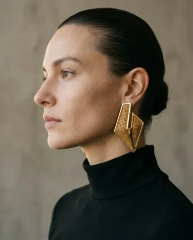 Sculptural Bold Earring Minimalist Close-Up Portrait 2 — Nano Banana AI Prompt: Minimalist close-up fashion portrait of a female model wearing a high-neck struc...