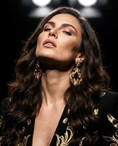Bold Opulent Gold Statement Earring Dramatic Portrait 4 — Nano Banana AI Prompt: Dramatic studio fashion close-up framed from the chin to the upper chest. A fema...