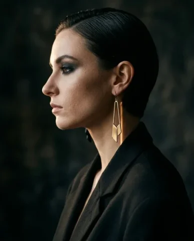 Edgy Smoky Eye Gold Earring Moody Editorial Portrait 2 — Nano Banana AI Prompt: Vertical editorial close-up of a female model in a matte black oversized blazer....