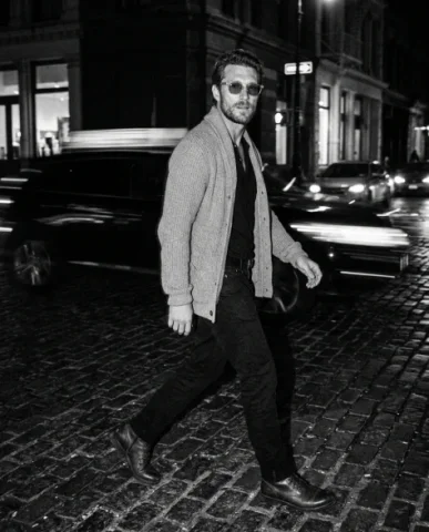 Black-and-White Menswear Editorial — Urban Night 5 — Nano Banana AI Prompt: An adult male with rugged features and a trimmed stubble beard walks away from t...