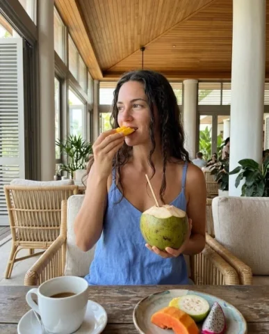 Casual Smartphone Vacation Breakfast Portrait 1 — Nano Banana AI Prompt: Seating is light-colored textured rattan with natural linen cushions. Centered w...