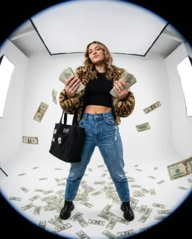 Fisheye Studio Portrait with Scattered Cash 1 — Nano Banana AI Prompt: Hair styled in soft defined waves with a sleek side part. White box-style studio...