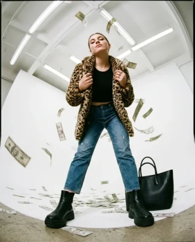 Fisheye Studio Portrait with Scattered Cash 4 — Nano Banana AI Prompt: Her other hand rests on her hip. The fan of bills is in sharp focus, individual...