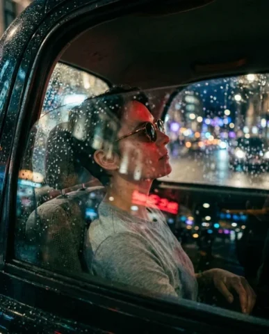 Rainy Night Taxi Cinematic Through Window 4 — Nano Banana AI Prompt: Cinematic extreme close-up of the subject's dark-tinted round sunglasses with th...
