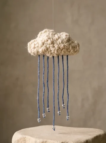A Rain Cloud Made of Yarn — Nano Banana 2 AI Prompt: A tactile original conceptual craft photograph of a single small cloud sculpted...