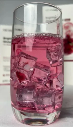 Macro Pink Beverage Photography — GPT Image 2.5 AI Prompt: A photorealistic close-up of a tall, crystal-clear cylindrical glass filled with...