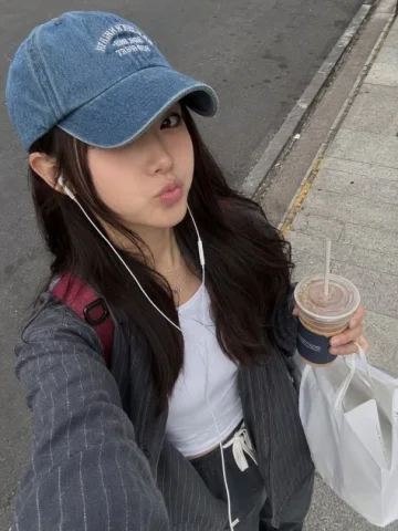 Casual Urban Selfie Portrait — GPT Image 2.5 AI Prompt: A photorealistic candid street-style selfie of a young woman walking outdoors on...