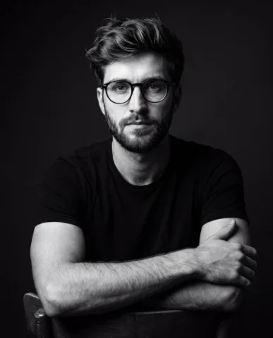 Cinematic Male Studio Portrait — Nano Banana 2 AI Prompt: A dramatic black-and-white studio portrait of a young man wearing a plain black...