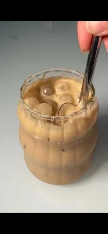 Stirred Iced Honey Latte Close-Up — GPT Image 2.5 AI Prompt: Create a photorealistic vertical 9:16 close-up image of an iced honey latte in a...