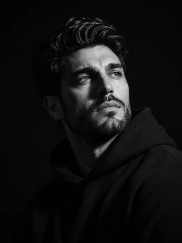 Cinematic Black and White Studio Portrait — GPT Image 2.5 AI Prompt: A cinematic black-and-white studio portrait of a handsome adult man with short,...