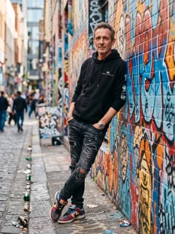 Urban Streetwear Man by Graffiti Wall — Nano Banana 2 AI Prompt: Hyper-realistic portrait of a thin man, in his late 40s, 8K, DSLR clarity, cinem...