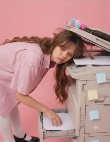 Pink Copier Fashion — Nano Banana 2 AI Prompt: A highly realistic conceptual fashion editorial photograph of a young woman stan...