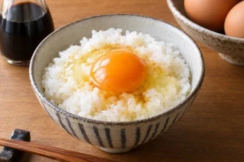 Photorealistic Tamago Kake Gohan — GPT Image 2.5 AI Prompt: Create a photorealistic food photography image of tamago kake gohan, Japanese ri...