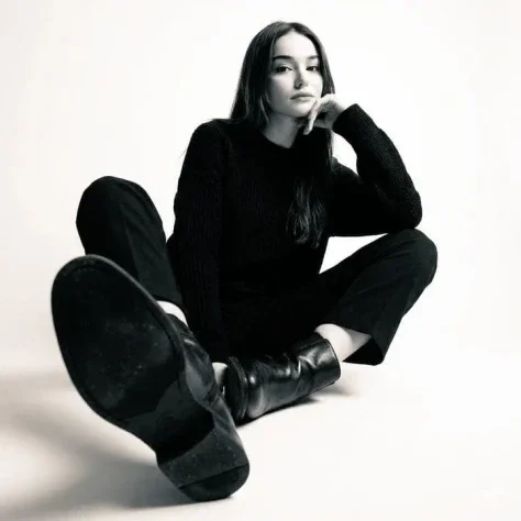 High-Contrast Black-and-White Boot Studio Photo — Nano Banana 2 AI Prompt: High-contrast black-and-white studio photo of a woman seated on the floor wearin...