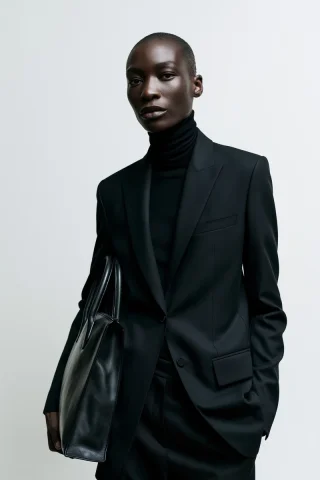 Black Suit and Structured Leather Bag — Nano Banana 2 AI Prompt: minimalist luxury fashion editorial, dark-skinned female model, wearing a sharp...