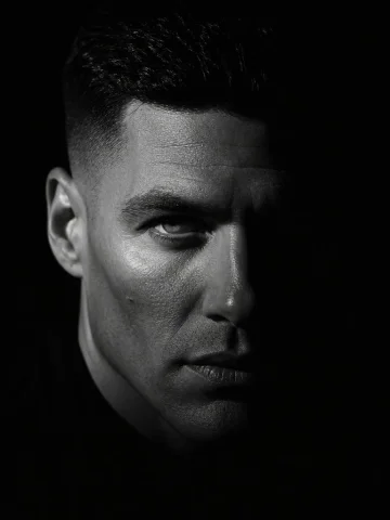 Dramatic Chiaroscuro Male Editorial Portrait — Nano Banana 2 AI Prompt: Indoor studio setting, pitch-black background, absence of ambient light. 33-yea...