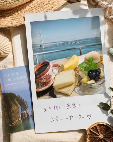 Awaji Island Flatlay — Nano Banana 2 AI Prompt: A sunlit seaside travel flat lay featuring an Awaji Island Polaroid breakfast sc...
