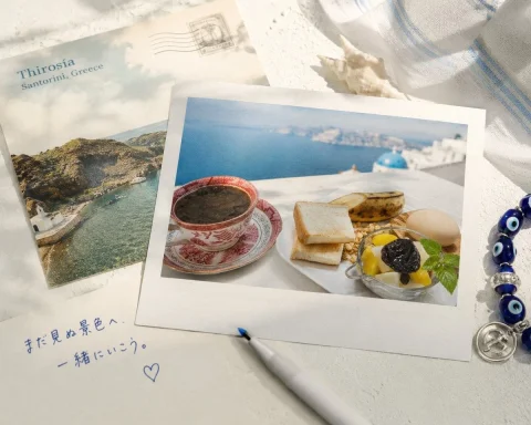 Santorini Breakfast Flatlay — Nano Banana 2 AI Prompt: A photorealistic Mediterranean vacation flat lay featuring postcards, a breakfas...