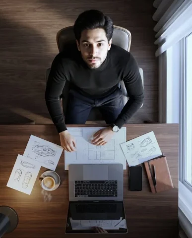 Birds-Eye Luxurious Workspace Black Turtleneck Portrait — Nano Banana 2 AI Prompt: An extreme high-angle, bird's-eye portrait shot captured with a wide-angle lens,...