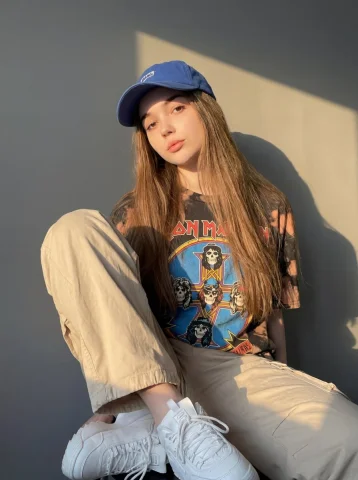 Urban Street Blue Cap Casual Streetwear Girl Portrait — Nano Banana 2 AI Prompt: A girl wearing a casual streetwear outfit, featuring a bold graphic t-shirt with...