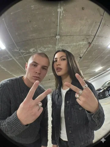 Fisheye Lens Underground Parking Garage Duo Selfie — Nano Banana 2 AI Prompt: { "scene": "Two young adults posing for a selfie in an underground parking garag...