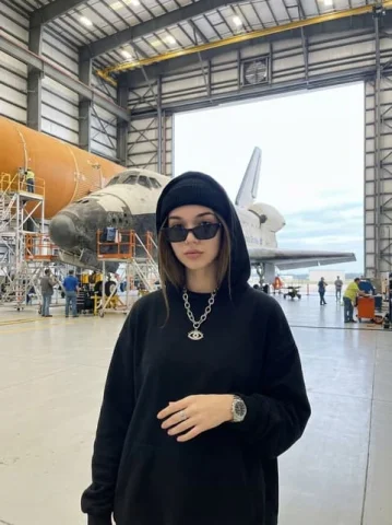 Aerospace Hangar Streetwear Portrait — Nano Banana 2 AI Prompt: { "image_generation": { "subject": { "description": "stylish young woman standin...