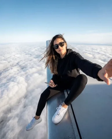 Airplane Wing Above Clouds Selfie — Nano Banana 2 AI Prompt: { "image_generation": { "subject": { "description": "stylish young woman sitting...