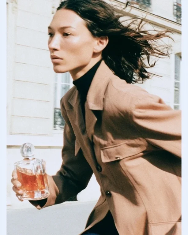 Girl Running Through Paris With Perfume