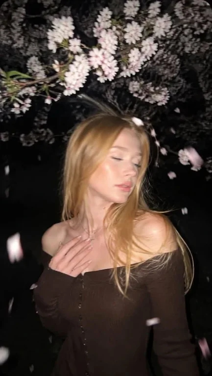 Girl under cherry blossoms with motion blur in creamy dress